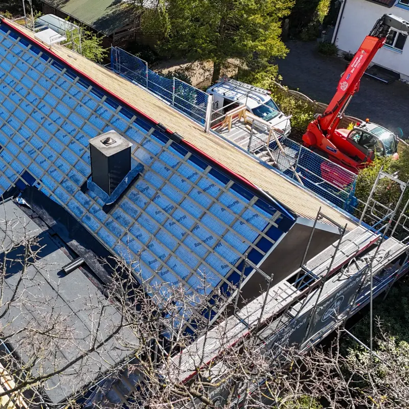 Drohnenaufnahme einer Dachsanierung der Zimmerei Der Holzprofi — Materialtransport per Telekran auf den Dachstuhl