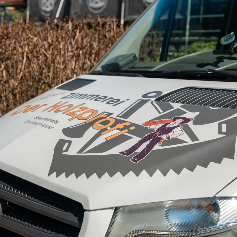 Mercedes-Sprinter der Zimmerei Der Holzprofi mit Zunftzeichen-Branding und Sven-Hinrichs-Schriftzug auf der Motorhaube