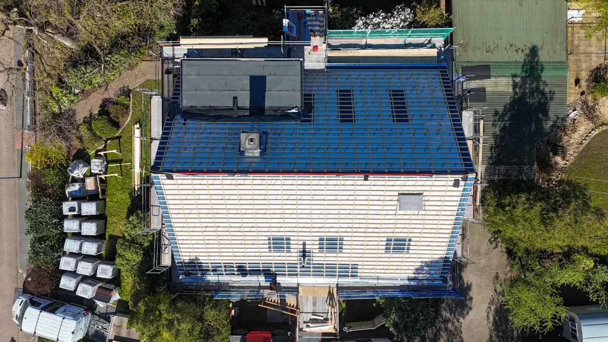 Drohnenaufnahme eines Mitbau-Hauses im Holzrahmenbau — Dachstuhl mit Konterlattung und Sub-Roof-Bahn, betreut durch die Zimmerei Der Holzprofi