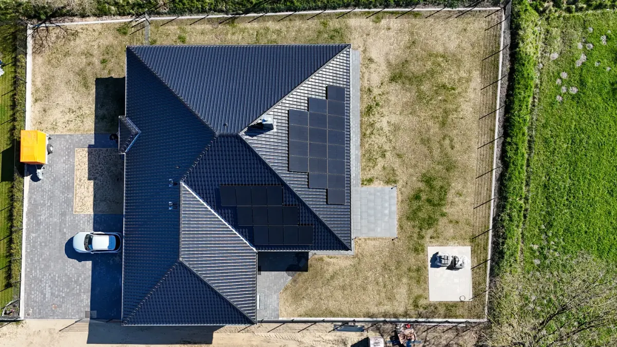 Top-down-Drohnenaufnahme eines fertiggestellten Wohnhauses mit Photovoltaik-Anlage — Referenz der Zimmerei Der Holzprofi